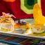 Colorful dishes at Asi es mi Peru restaurant in Aruba featuring ceviche towers with fresh fish, causa, plantain chips, and traditional Peruvian presentations