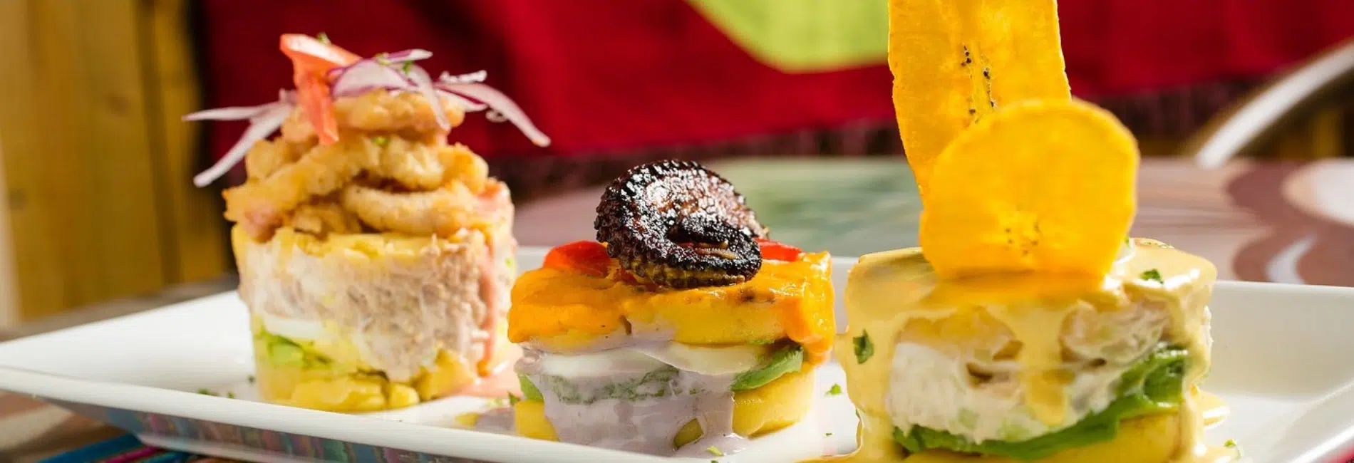 Asi es mi Peru Restaurant, Aruba Authentic Cuisine Colorful dishes at Asi es mi Peru restaurant in Aruba featuring ceviche towers with fresh fish, causa, plantain chips, and traditional Peruvian presentations