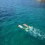 Two snorkelers swimming in vibrant turquoise Caribbean water in Aruba with snorkel gear and fins, viewed from above