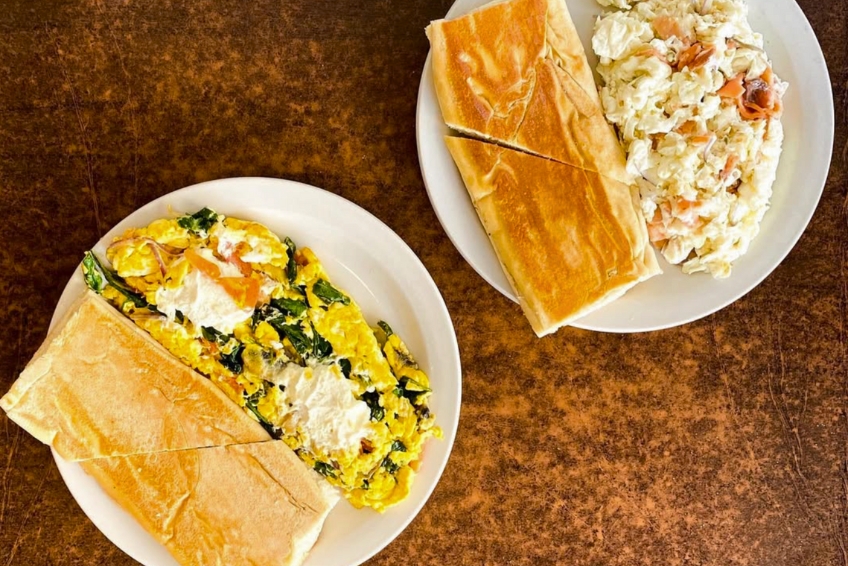 Traditional breakfast at Pinky's Restaurant in Puerto Rico with scrambled eggs with spinach, toasted bread, creamy coleslaw, and classic diner-style presentation